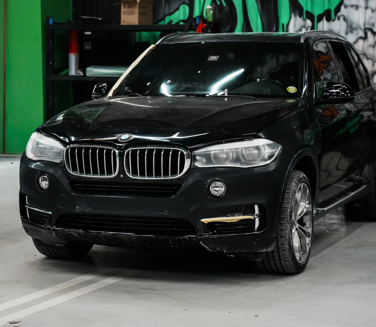 A BMW X5 in a service bay at the Exotic Auto Services workshop in Mussafah