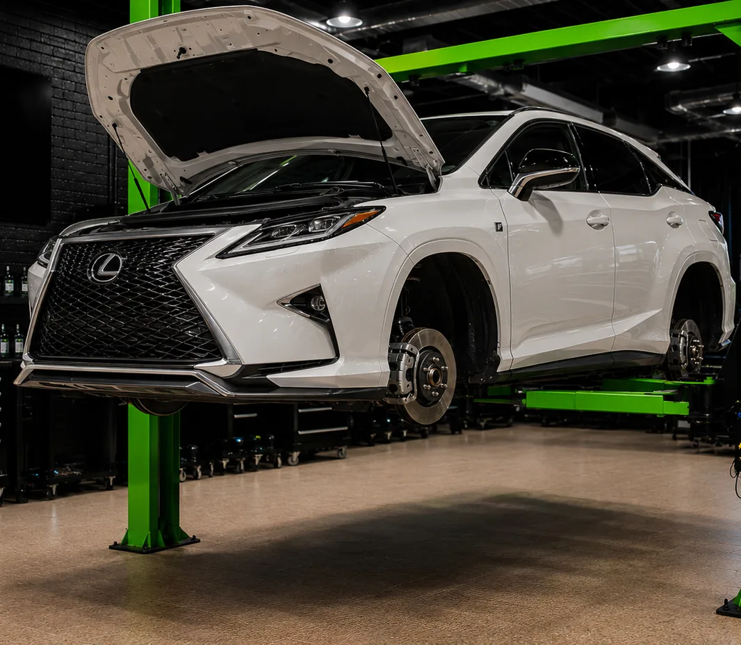 A Lexus raised on a two-post lift in the Mussafah workshop